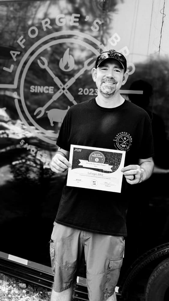 LaForge's BBQ owner holding the Best of the Four States 2026 BBQ award certificate